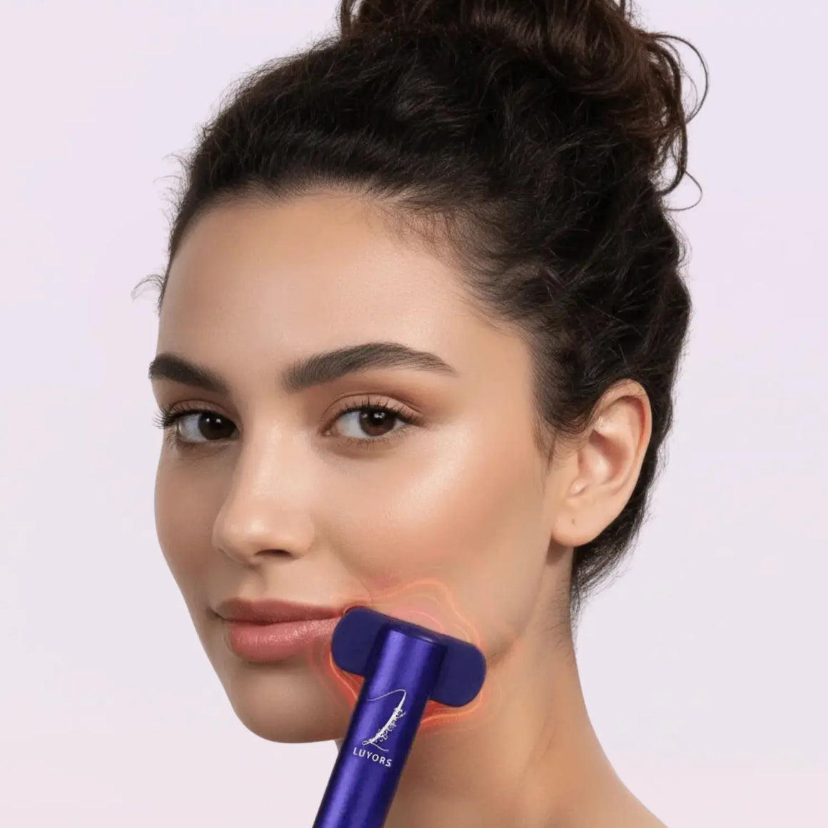 Woman-gliding-purple-Chromaglow-LED-wand-upward-along-her-jawline-with-red-light-therapy-glowing-on-her-skin